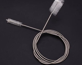 May include: Two silver cleaning brushes with long, flexible wire handles. The brushes have white bristles and are designed for cleaning narrow spaces.
