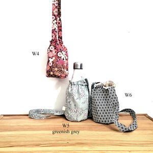 May include: Floral fabric water bottle carriers in pink, greenish grey, and black and white patterns. The carriers have drawstring closures and straps. The text "W4", "W5 greenish grey", and "W6" are visible.