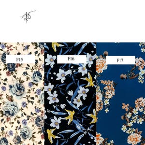 May include: Three fabric swatches with floral patterns. The first is cream-colored with blue roses and purple accents, labeled F15. The second is black with white flowers and yellow birds, labeled F16. The third is navy blue with orange and white flowers, labeled F17.