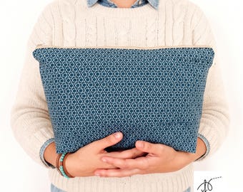 May include: A rectangular zippered pouch featuring a dark teal fabric with a repeating white geometric pattern of interconnected six-pointed stars. The pouch has a light-colored zipper closure along the top edge and a structured shape.