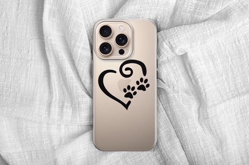 May include: A gold-colored phone case featuring a black heart design with two paw prints. The case has a clear, protective design and is likely made of durable material. The phone case is a pet-themed accessory.