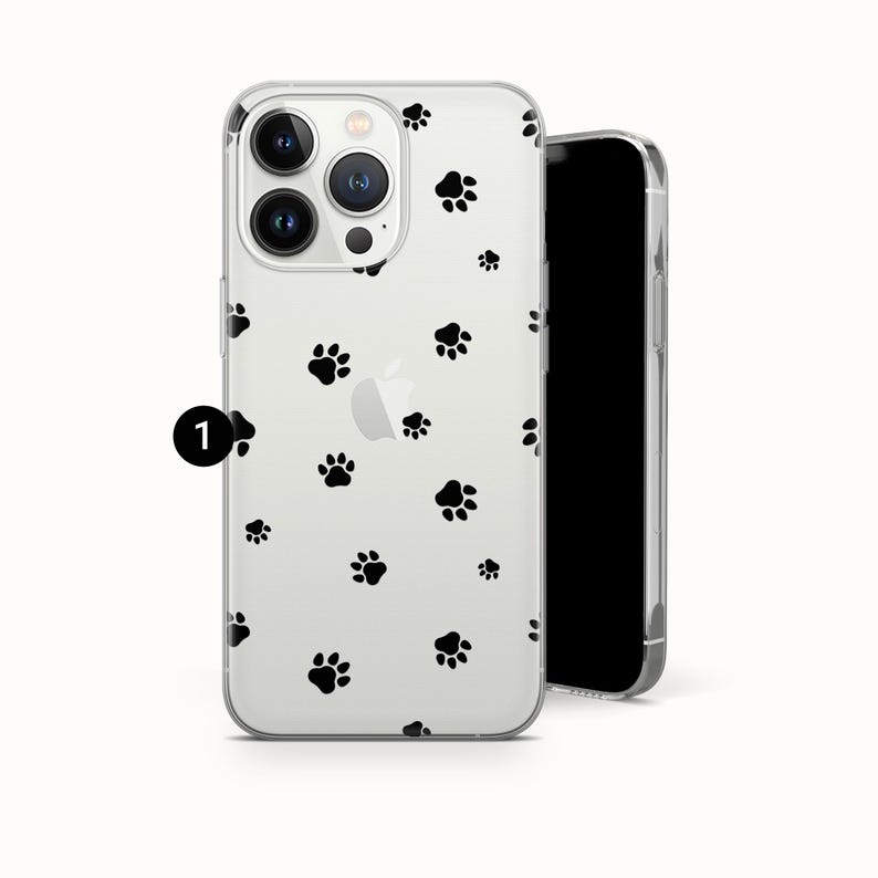 May include: Clear phone case with a pattern of black paw prints. The case is designed to fit a smartphone, with cutouts for the camera and buttons. The phone case is made of a transparent material, allowing the phone's color to show through.