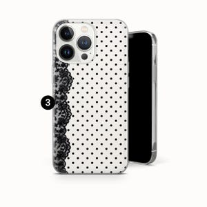 May include: A clear phone case with a white background and black polka dots. A black lace design runs vertically along the left side. The phone case is shown with a black phone inside.