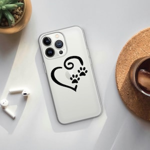 May include: Clear phone case featuring a black heart design with paw prints. The case is made of a transparent material, allowing the phone's color to show through. The design is simple and elegant, perfect for pet lovers.