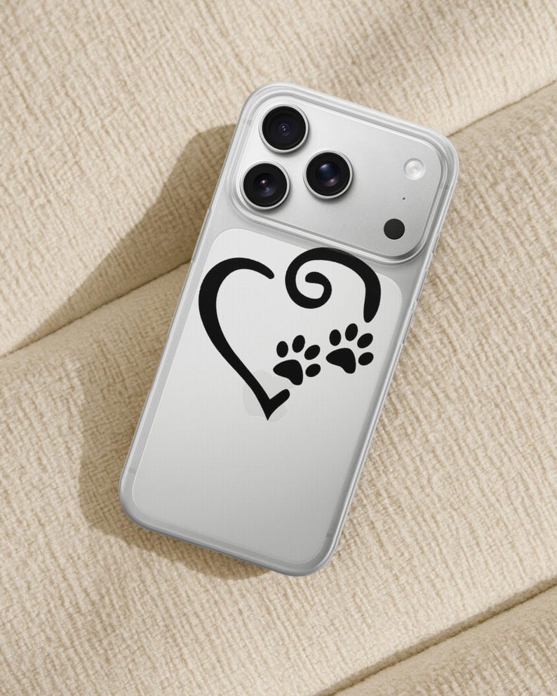 May include: Clear phone case with a black heart and paw print design. The case has a clear back and a protective bumper. The design features a heart shape with a swirl and two paw prints, perfect for pet lovers.