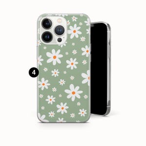 Pode incluir: Uma capa de telefone com um padr&atilde;o floral de margaridas. A capa tem um fundo verde claro com margaridas brancas e laranja. A capa do telefone est&aacute; em um fundo branco.