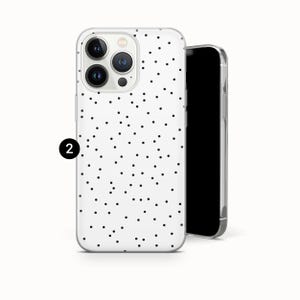 May include: A white phone case with a black polka dot pattern. The case is shown with a black smartphone. The phone case has a clear, protective design.