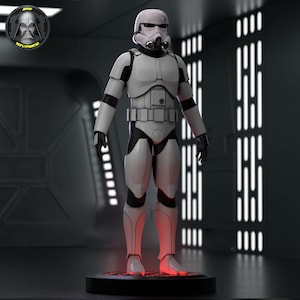 May include: A white stormtrooper action figure with a black and white helmet and a black belt. The figure is standing on a black circular base with a red light underneath.