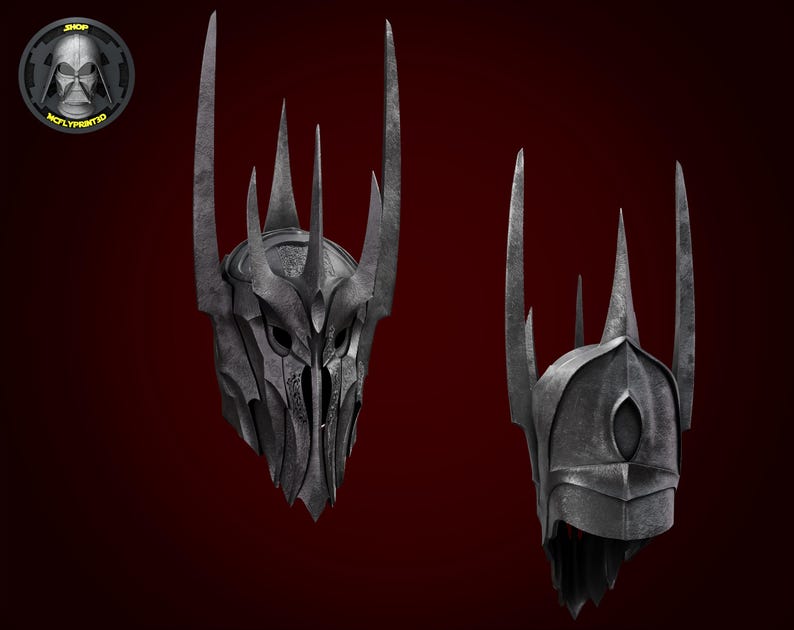 Puede incluir: Un casco de metal negro con una corona de p&uacute;as. El casco tiene una m&aacute;scara facial con un solo agujero para el ojo.