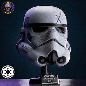 Könnte beinhalten: Ein weiß-grauer Stormtrooper-Helm mit schwarzen Akzenten, auf einem schwarzen Ständer. Der Helm hat ein verwittertes Aussehen mit einem 'X'-Design auf der Stirn. Auf dem Sockel steht "STAR WARS TASK FORCE 99 CAV Scar Squadron."