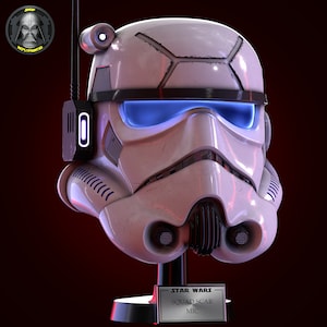 May include: White and black Star Wars Squad Scar Stormtrooper helmet with blue visor on a black stand. The stand has a silver plaque with the text "STAR WARS SQUAD SCAR MIC".