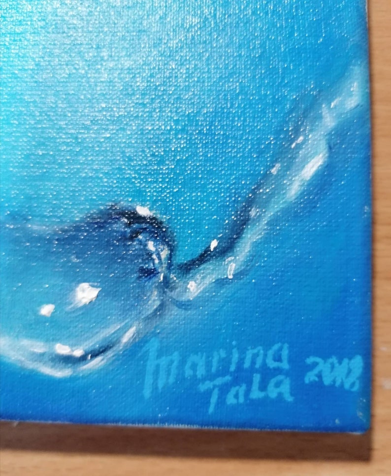 May include: A blue and white abstract painting with a signature in the bottom right corner that reads "Marina Tala 2018".