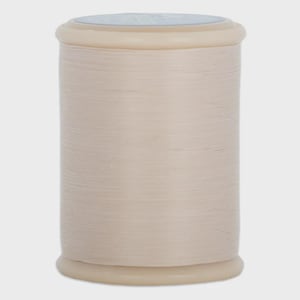 May include: A beige thread spool, tightly wound on a cylindrical core. The thread is a light, neutral colour, and the spool has a pale, off-white top and bottom. The thread appears smooth, suitable for sewing or craft projects.