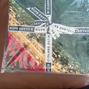 Puede incluir: Una taza de cerámica blanca con asa negra y el texto "But First, Coffee" en negrita negra. La taza se encuentra sobre un fondo borroso, sugiriendo un ambiente acogedor.