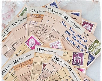 Op de afbeelding: Een verzameling vintage ansichtkaarten met handgeschreven adressen en postzegels. De ansichtkaarten zijn verkleurd door de tijd en hebben een versleten, rustieke uitstraling. Sommige ansichtkaarten hebben postzegels met afbeeldingen van gebouwen en andere ontwerpen.