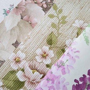 May include: Four different patterns of vintage wallpaper with floral designs in shades of pink, white, and green. The patterns include small pink flowers, large white flowers, pink and white flowers, and a leafy vine pattern.
