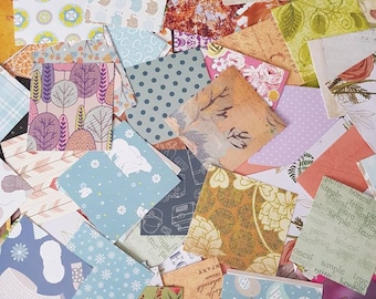 May include: A collection of colorful patterned paper squares, featuring various designs including floral, geometric, and animal prints. The papers are arranged in a random pile, showcasing a variety of textures and colors.
