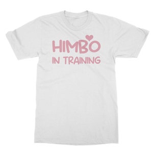 Peut inclure: T-shirt blanc avec l'inscription rose "HIMBO IN TRAINING". Un cœur rose est au-dessus du "O" de "HIMBO". Le t-shirt est à col rond et à manches courtes.