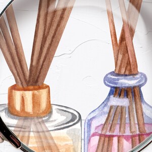 May include: Two glass bottles with brown wooden sticks inside. The bottles are filled with a clear liquid and a pink liquid. The bottles have a gold and blue lid.