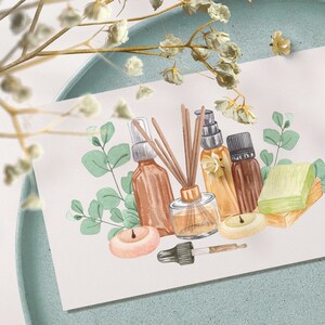 May include: A watercolor illustration of a collection of essential oil bottles, candles, and a diffuser with sticks. The bottles are brown and clear glass with gold lids. The candles are white and peach. The diffuser is clear glass with a gold lid and brown sticks. The illustration is surrounded by green eucalyptus leaves.