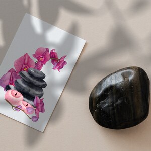 May include: A watercolor illustration of pink orchids and black stones arranged in a stack, with two pink candles on the bottom. The illustration is on a white card.