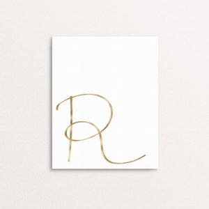 May include: A gold metallic cursive letter R on a white background.