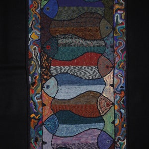 May include: A colorful rug with a design of seven fish in a row. The fish are outlined in black and have a variety of colors, including blue, green, red, and brown. The rug has a border of swirling, colorful lines.
