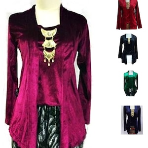 Puede incluir: Una colección de cinco blusas de terciopelo con cuello alto y mangas largas. Las blusas son de diferentes colores: burdeos, rojo, negro, verde y azul. Cada blusa tiene un colgante dorado decorativo en la parte delantera.