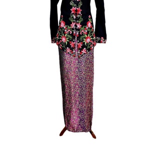 May include: A black embroidered top with red and pink floral designs, paired with a purple and gold patterned skirt.