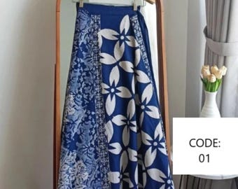 May include: A blue and white patterned wrap skirt with a floral design. The skirt is hanging on a wooden hanger in front of a mirror. CODE: 01