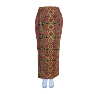 May include: A long, pink, black, and gold skirt with a geometric pattern. The skirt is made of a woven fabric and has a high waist.