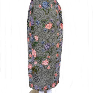 May include: A long, gray skirt with a floral pattern. The skirt has a waistband and is made of a soft, flowing fabric. The flowers are pink, blue, and purple.