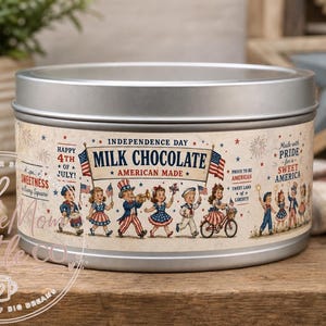 Op de afbeelding: Een ronde, zilveren blikje melkchocolade met een vintage Independence Day-ontwerp. Het etiket luidt "Milk Chocolate American Made" met illustraties van kinderen, vlaggen en vuurwerk. Het blikje staat op een houten oppervlak.
