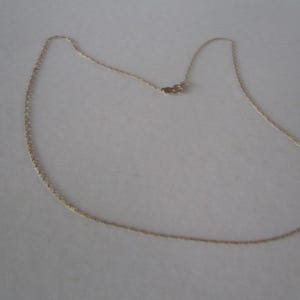 May include: A gold chain necklace with a lobster clasp.