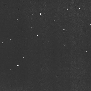 May include: A monochrome image showing a night sky with many bright, white stars of different sizes. The stars are spread across a dark, textured background, forming a celestial pattern.