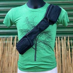 Puede incluir: Una riñonera negra con varios compartimentos con cremallera que se lleva en diagonal sobre el pecho de un maniquí que lleva una camiseta verde con un gráfico de un árbol.