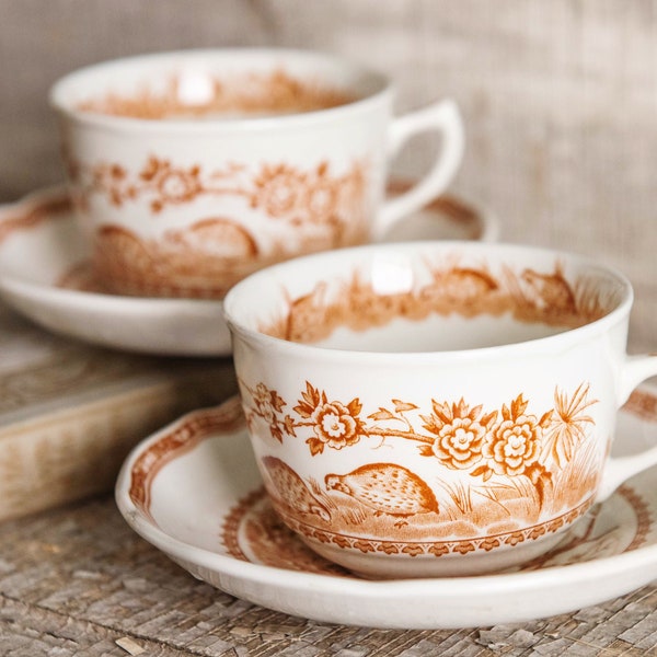 Two Furnivals Quail tea cups and saucers - a pair of 1921 brown transferware English ironstone cups