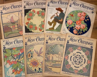Op de afbeelding: Een verzameling vintage Franse tijdschriften "Mon Ouvrage", met kleurrijke Art Nouveau-illustraties. De covers tonen diverse ontwerpen, waaronder bloemstukken, landschappen en figuren, met Franse tekst.