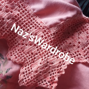 May include: Close-up of a pink garment with a crocheted lace trim. The lace is a lighter shade of pink and features a delicate openwork design. The text "Naz's Wardrobe" is visible on the garment.