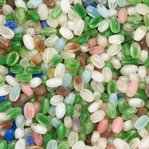 Pu&ograve; includere: Una collezione di perline di vetro ovali in vari colori, tra cui bianco, verde, blu e rosa. Le perline hanno un aspetto traslucido e smerigliato.