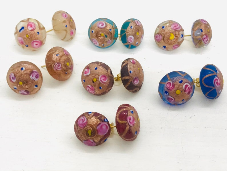 May include: Assortment of colorful glass earrings with gold accents and pink, blue, and white floral patterns.