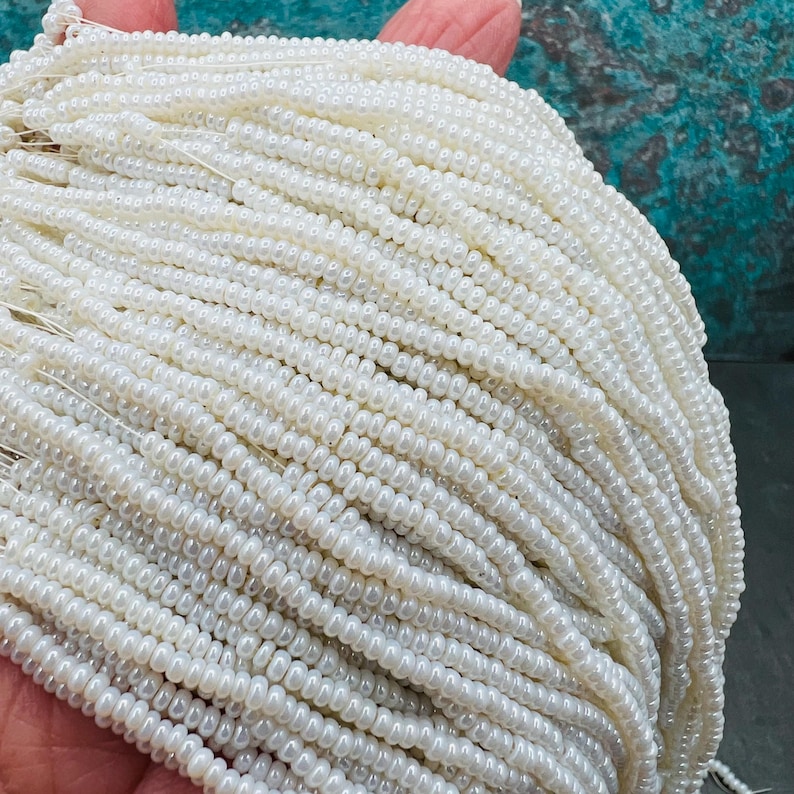 May include: A large strand of white seed beads, perfect for jewelry making or crafting.