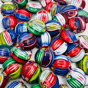 May include: A collection of colorful glass beads with intricate striped patterns in red, blue, green, white, and yellow. The beads are oval-shaped and have a glossy finish.
