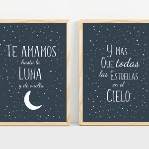 May include: Two framed prints with a dark blue background and white stars. The left print says "Te amamos hasta la luna y de vuelta" with a crescent moon. The right print says "Y mas que todas las estrellas en el cielo".