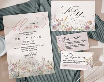 Puede incluir: Un conjunto de papelería para baby shower con diseños florales. La invitación dice "Baby in Bloom" e incluye detalles para la fiesta de Emily Rose. Tarjetas adicionales dicen "Thank You", "Books for Baby" y "Diaper Raffle". La papelería está sobre un fondo verde suave.