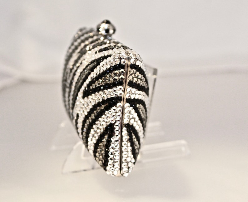 May include: A black and white zebra-print clutch purse covered in rhinestones.