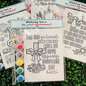May include: A collection of Christmas-themed coloring kits. Each kit includes a black and white line drawing, paint pots, and a paintbrush. The kits feature religious and festive designs with the text "Wishing You a Colorful Christmas!"
