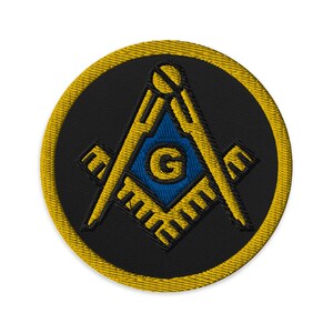 Könnte beinhalten: Runder, gestickter Aufnäher mit einem Freimaurer-Symbol. Das Design umfasst ein gelbes Quadrat und einen Zirkel, eine blaue Mitte mit dem Buchstaben "G" und einen schwarzen Hintergrund. Der Aufnäher hat einen gelben Rand.