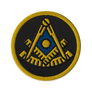 May include: A black and gold embroidered patch with a Masonic symbol, a compass and square, on a black background.