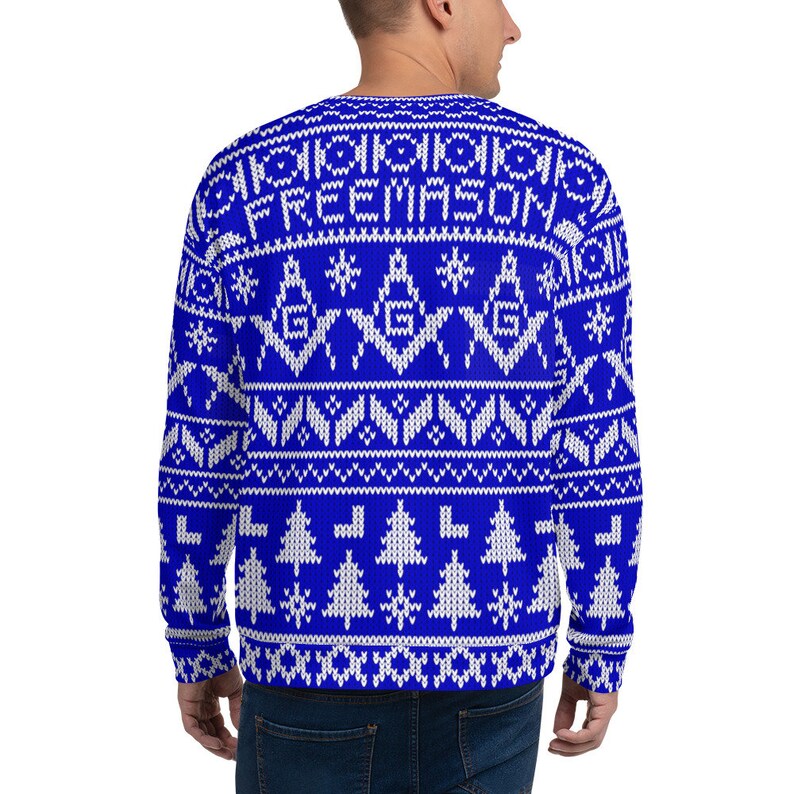 May include: A blue and white knitted sweater with a Christmas-style pattern. The sweater features a white snowflake design, white Christmas trees, and the words "FREEMASON" in white.